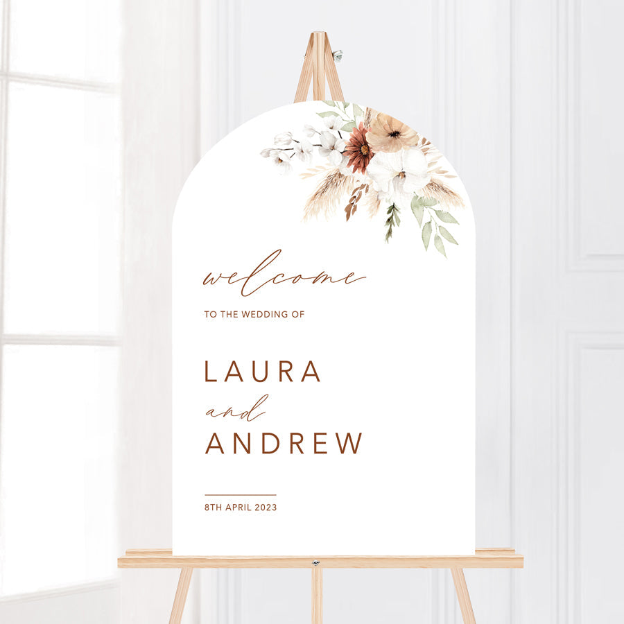 Modern arch shape wedding welcome sign board with boho florals and calligraphy.