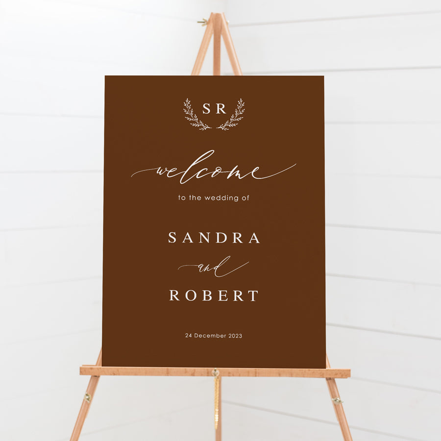 Wedding welcome sign board with calligraphy font and monogram of bride and grooms initials in deep harvest and white ink. Peach Perfect.