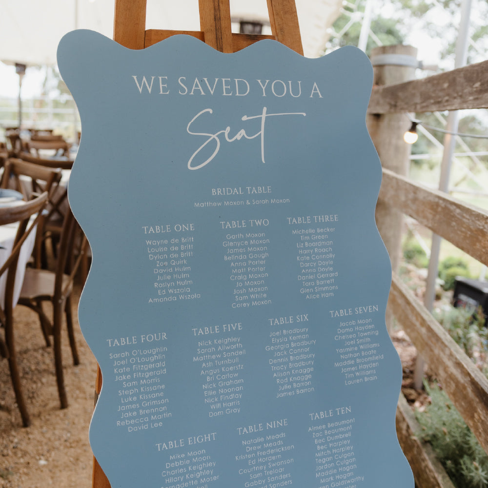 Billie wedding seating chart with playful wavy edges in dusty blue, featuring bold typography and modern styling.