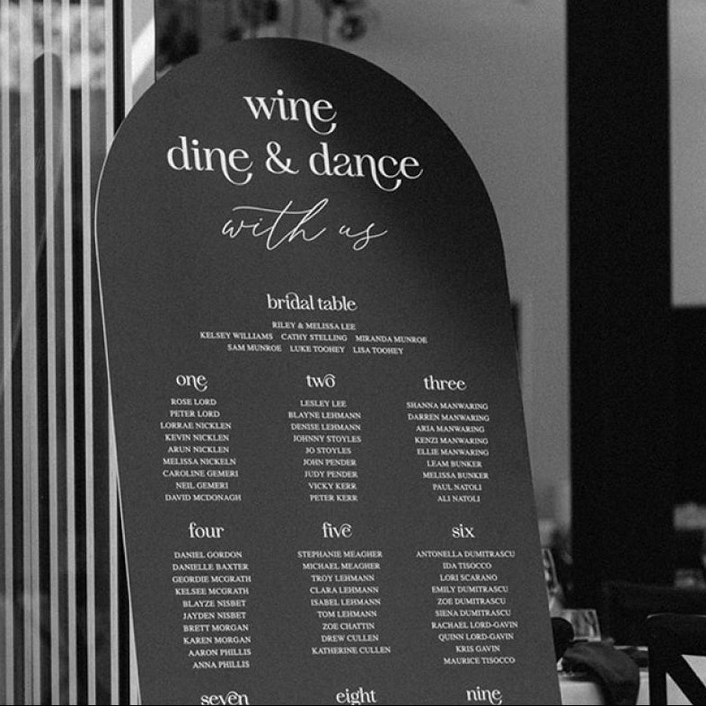 Modern minimal wedding seating chart in black and white "Wine Dine and Dance with us"