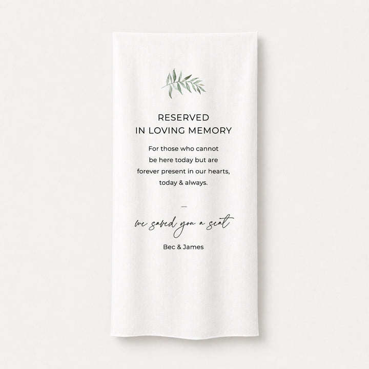 A white draped fabric memorial banner or fabric sign with elegant black text reading &