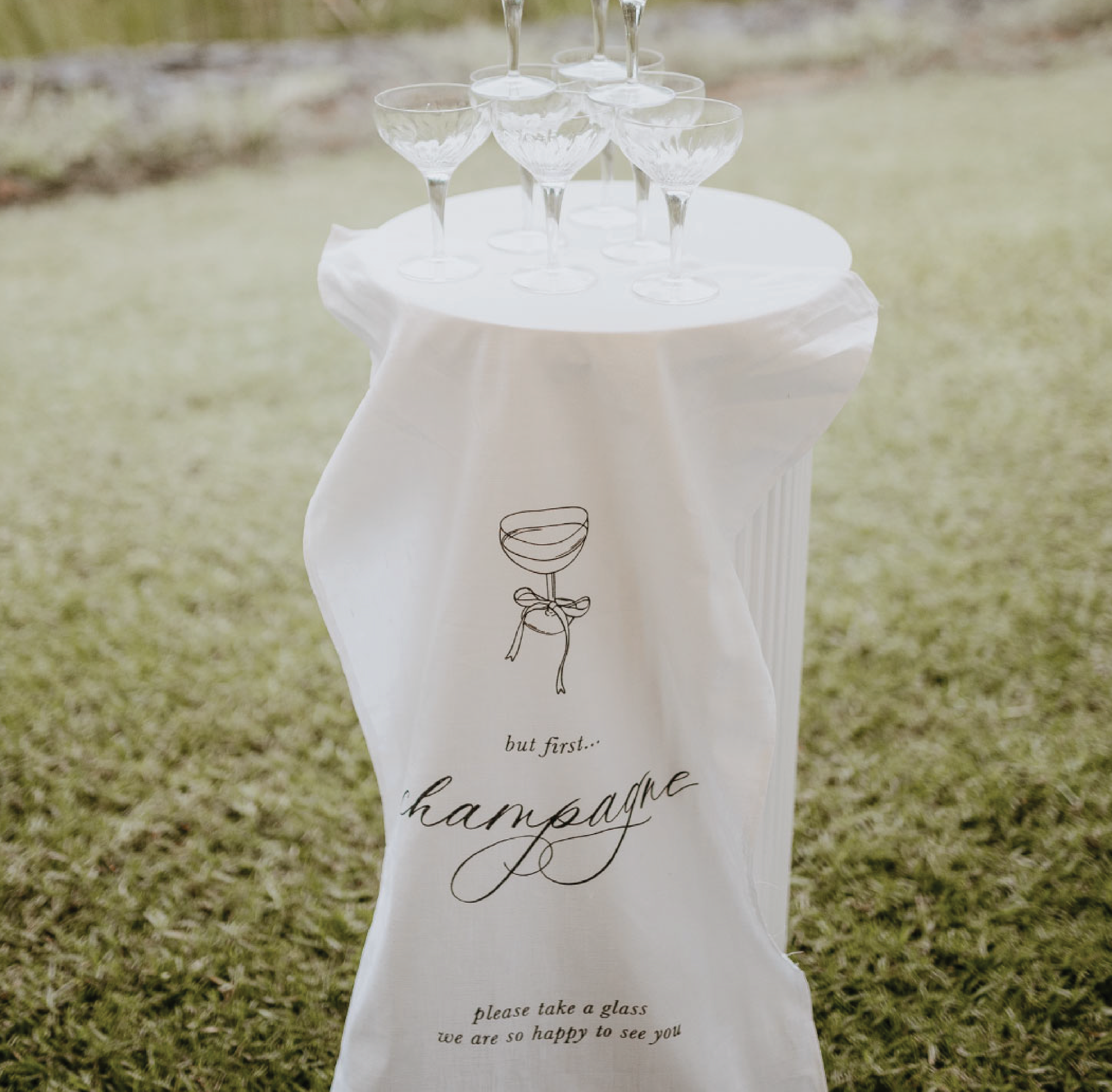 Linen fabric wedding sign for Bar with heading But First Champagne Tower.
