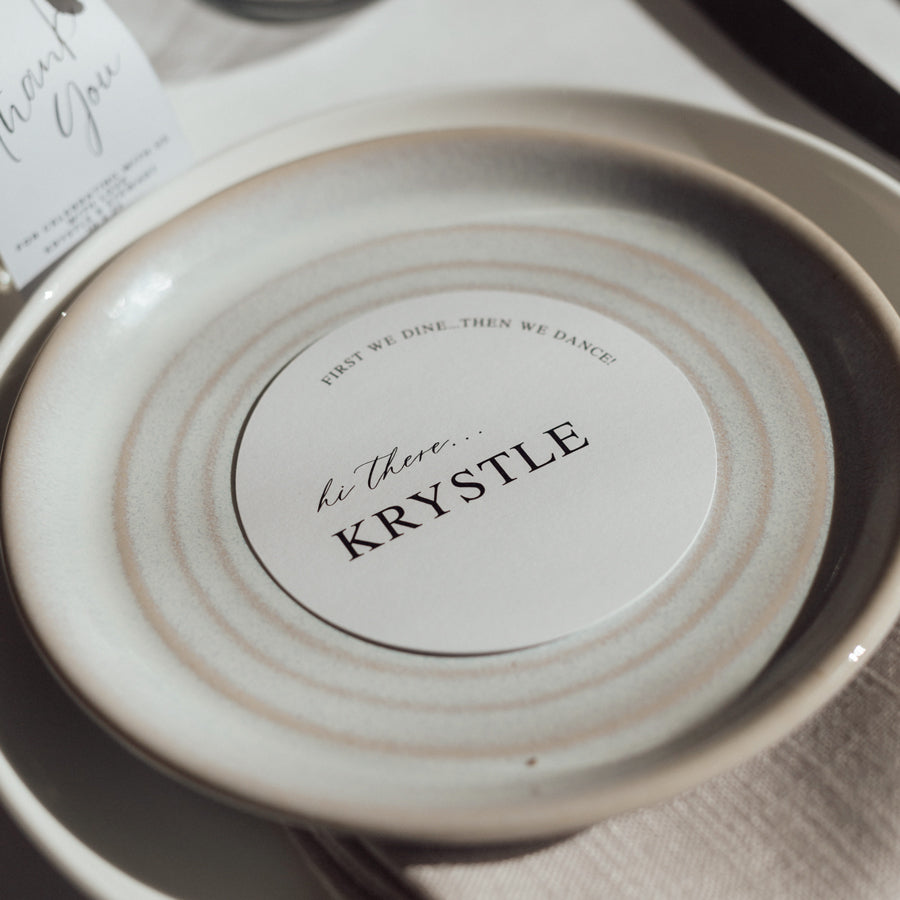 Classic wedding place cards with calligraphy in round shape on a white card