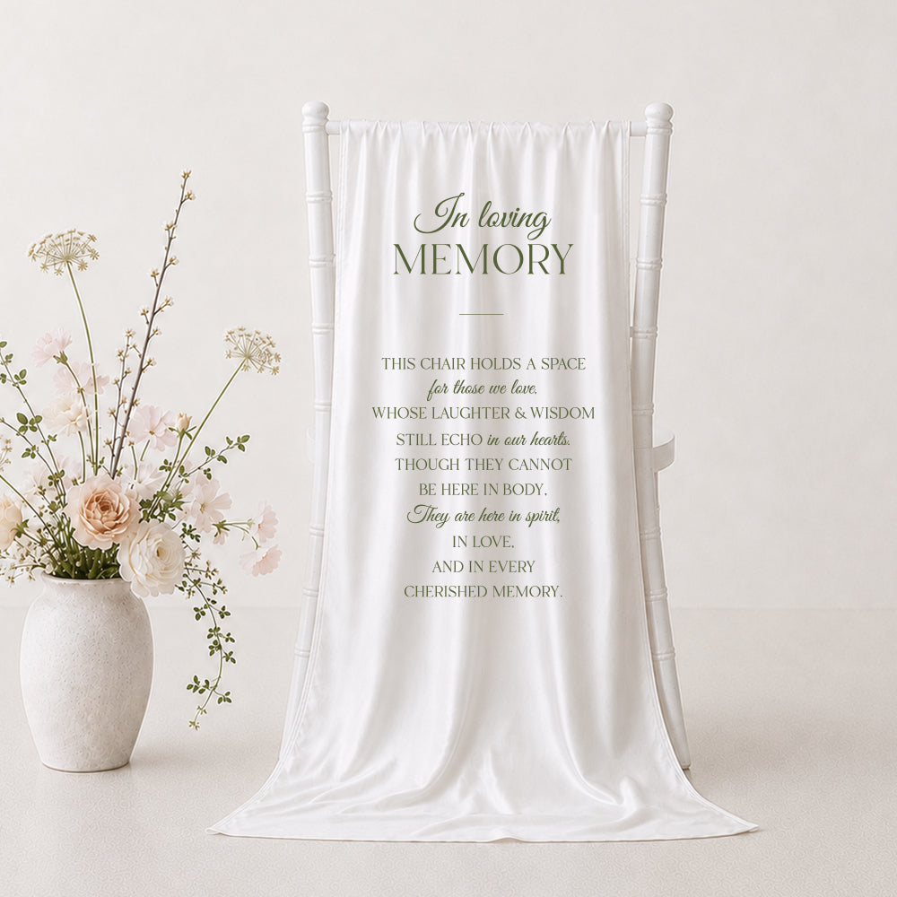 A white draped fabric memorial banner or tapestry with elegant black text reading &