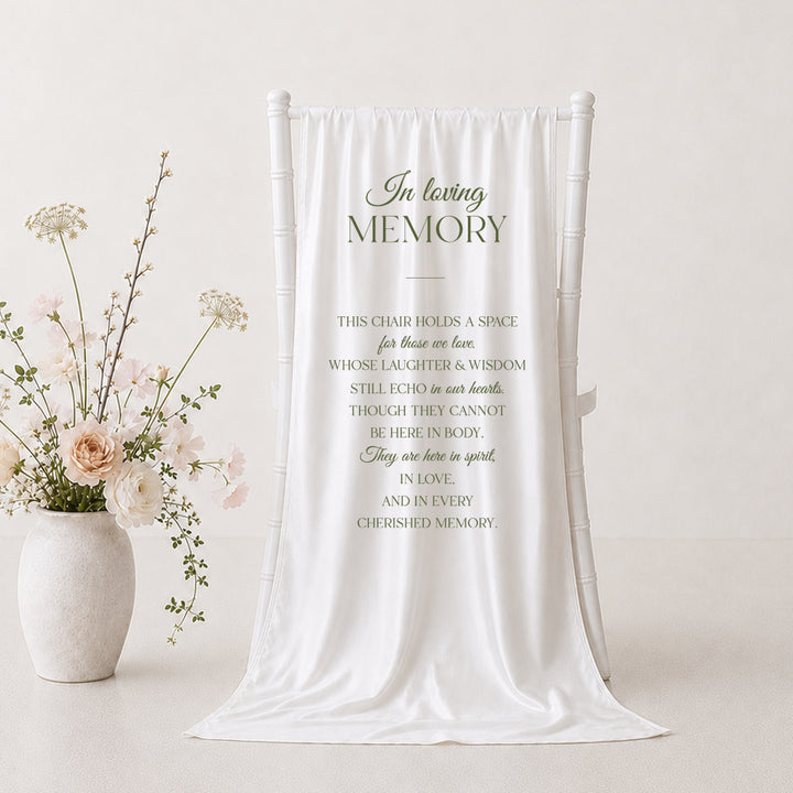 A white draped fabric memorial banner or tapestry with elegant black text reading &
