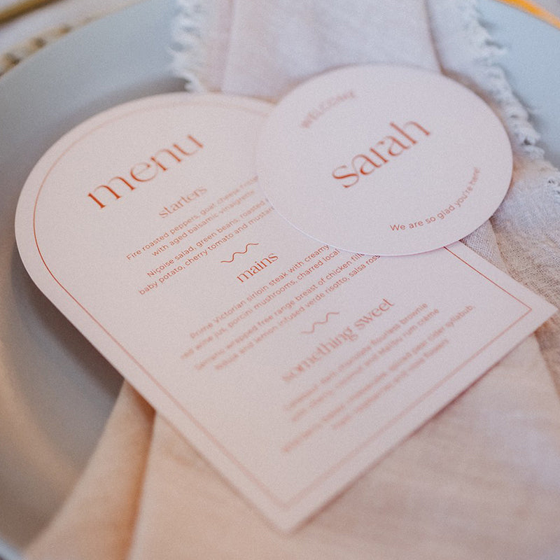 Modern arch shape wedding menu in peach and burnt orange with round place cards. Printed in Australia by Peach Perfect.
