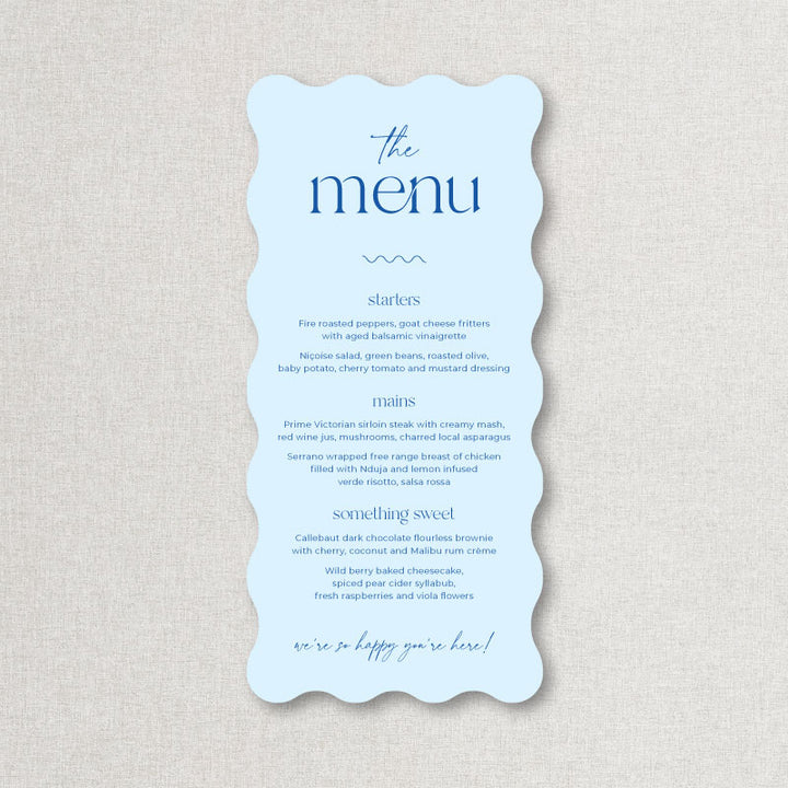 Light blue wedding menu in wavy die cut shape with blue text. Printed by Peach Perfect Australia.