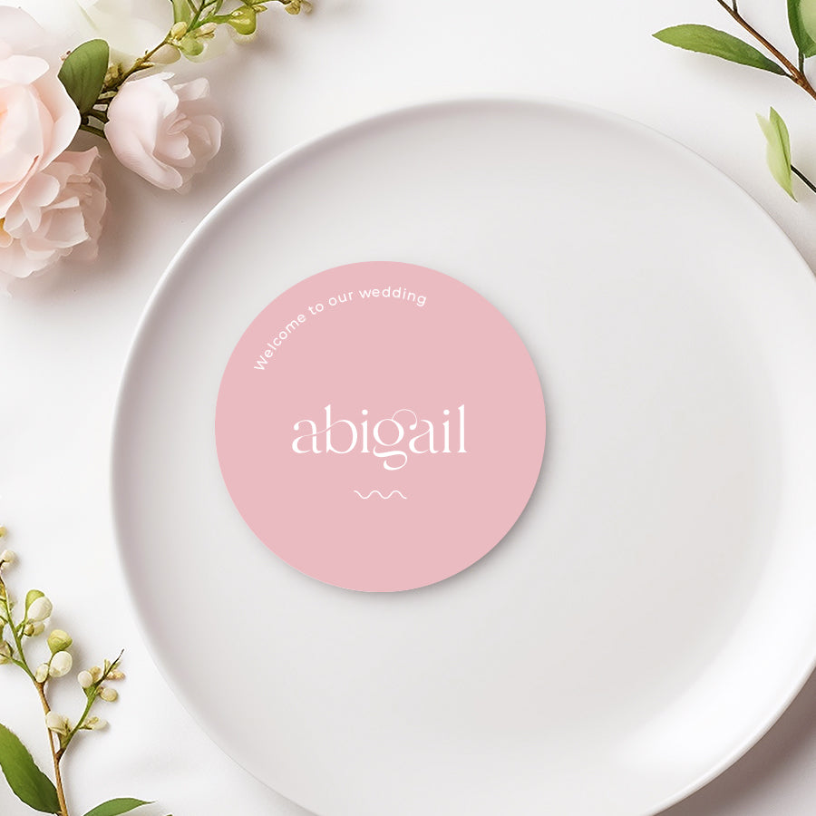 Modern minimalist round soft pink wedding and event place card with white text and wavy line. Welcome to our wedding note.