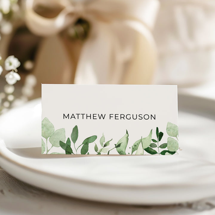 Traditional folded wedding place cards printed in Australia with greenery watercolour leaves and black text.