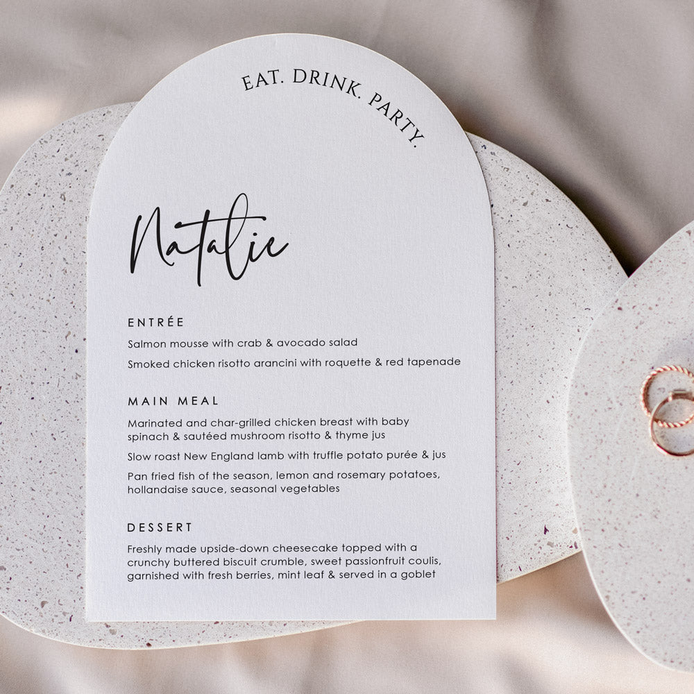 Arch shape wedding menu with eat drink party heading and guest name printing. Almond cardstock and black text. Designed in Australia.