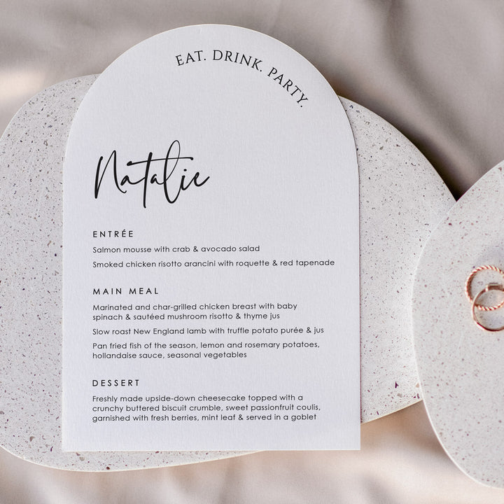 Arch shape wedding menu with eat drink party heading and guest name printing. Almond cardstock and black text. Designed in Australia.