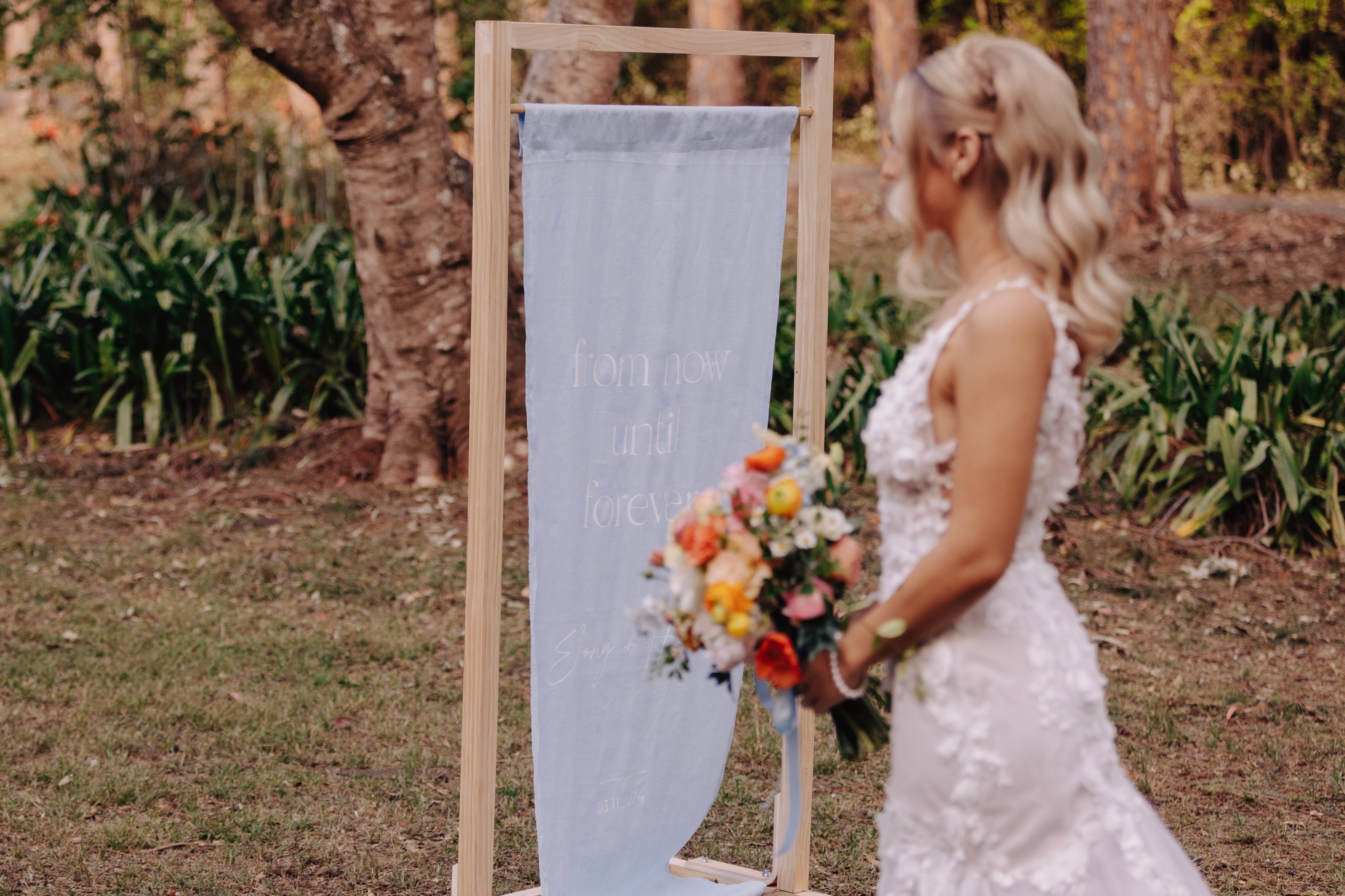 baby blue linen wedding welcome sign with bride in garden