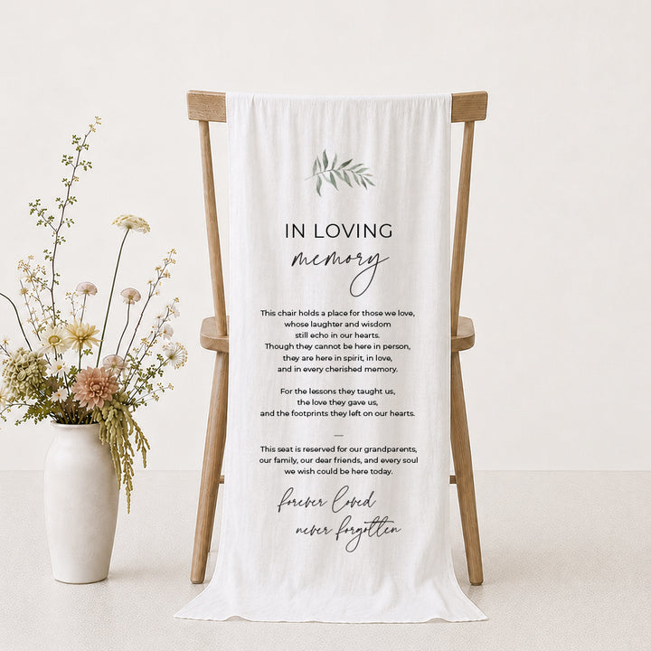 A white draped fabric memorial banner or fabric sign with elegant black text reading &