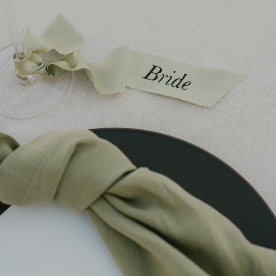 Wedding name tags printed on a silk ribbon and tied around a wine glass