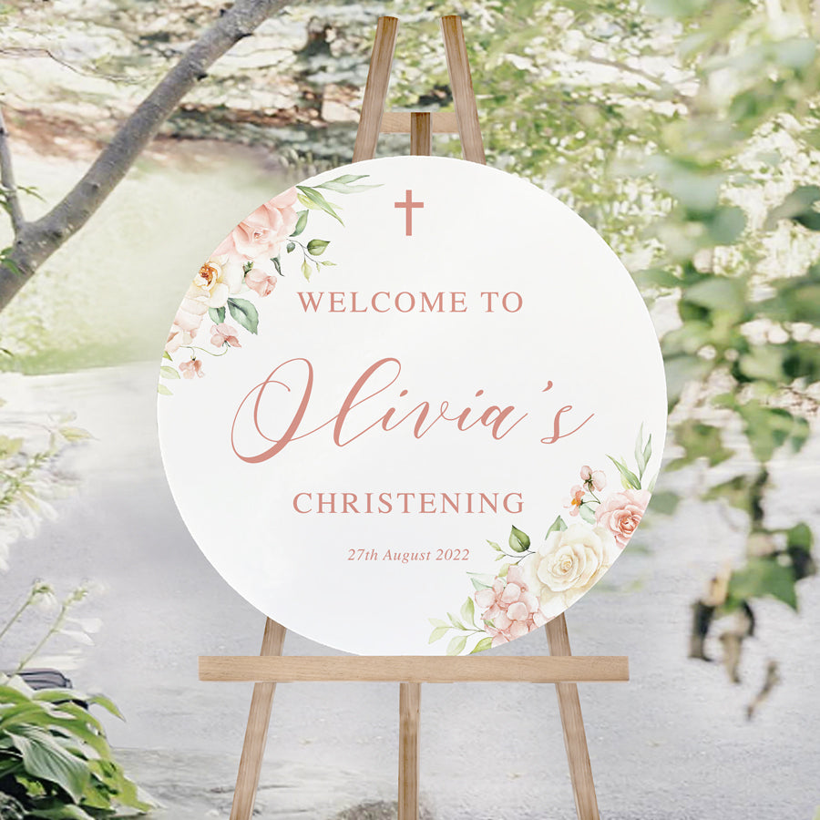 Round Baptism or Christening welcome sign with pink flowers and calligraphy text sitting on an easel. Australia.