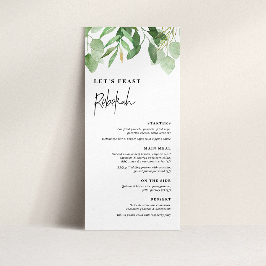 Wedding menu with greenery and eucalyptus leaves and modern font style with guest name printing.