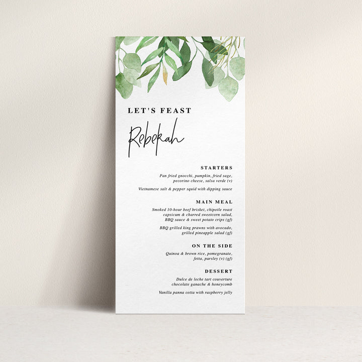 Wedding menu with greenery and eucalyptus leaves and modern font style with guest name printing.