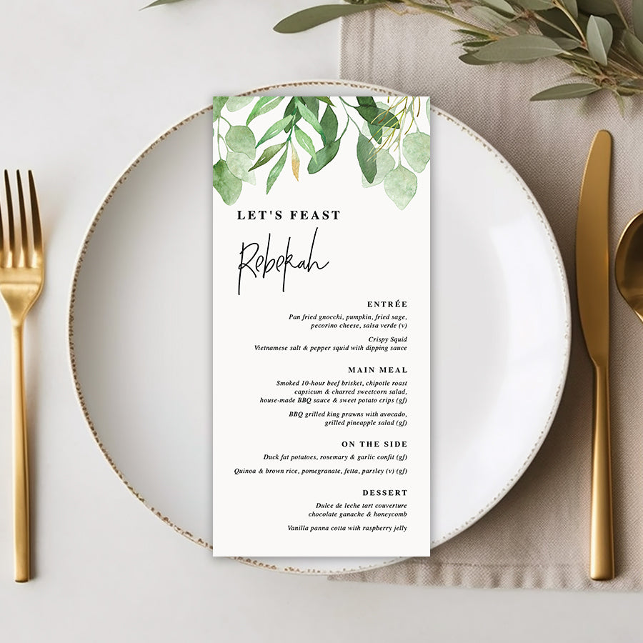 Wedding menu with greenery and eucalyptus leaves and modern font style with guest name printing.