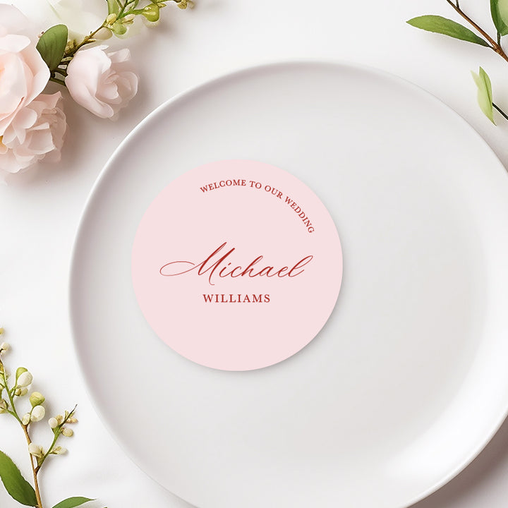 Calligraphy welcome to our wedding place cards in soft pink, die cut circle shape coasters. 

