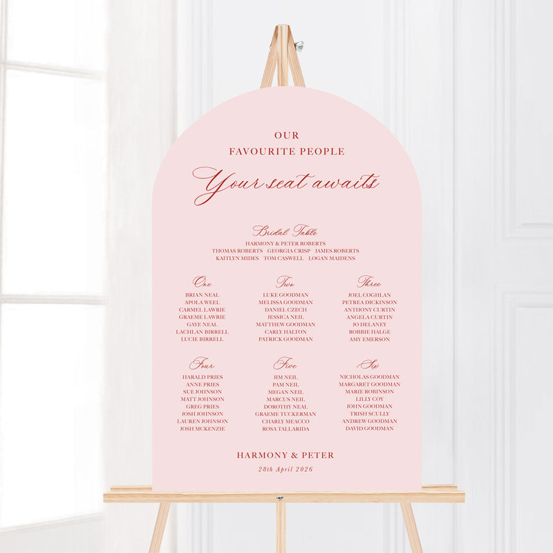 Wedding seating chart arch shape with traditional formal calligraphy in pink and terracotta red.