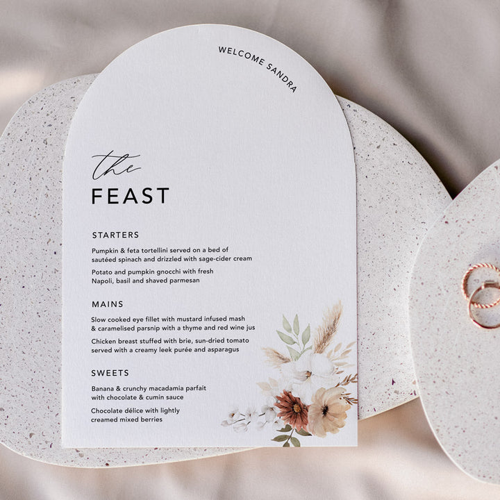 Boho floral wedding menu in Arch shape with guest name printing and the feast for heading. Peach Perfect Australia.