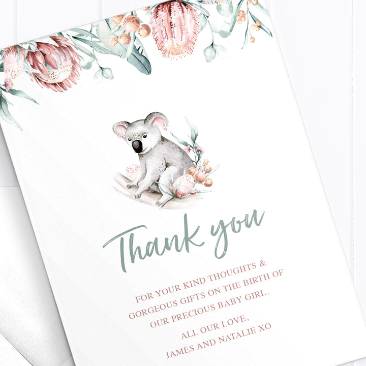Baby girl birth announcement card with photo of baby and australian native flowers and greenery border, with koala double sided