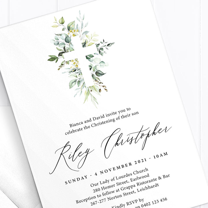 Boy Baptism and Christening invitation with beautiful detailed greenery cross and calligraphy for the name in black ink.