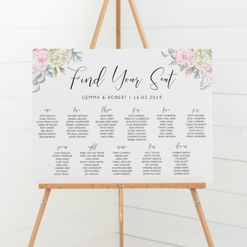 Wedding seating chart or guest name plan with calligraphy heading and soft pink flowers and greenery. Mounted to board for sitting on an easel.