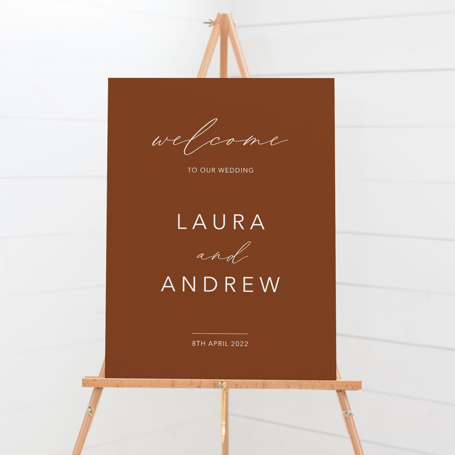 Modern boho wedding welcome sign with a terracotta background and white text. Printed in Australia on smooth board for sitting on an easel.