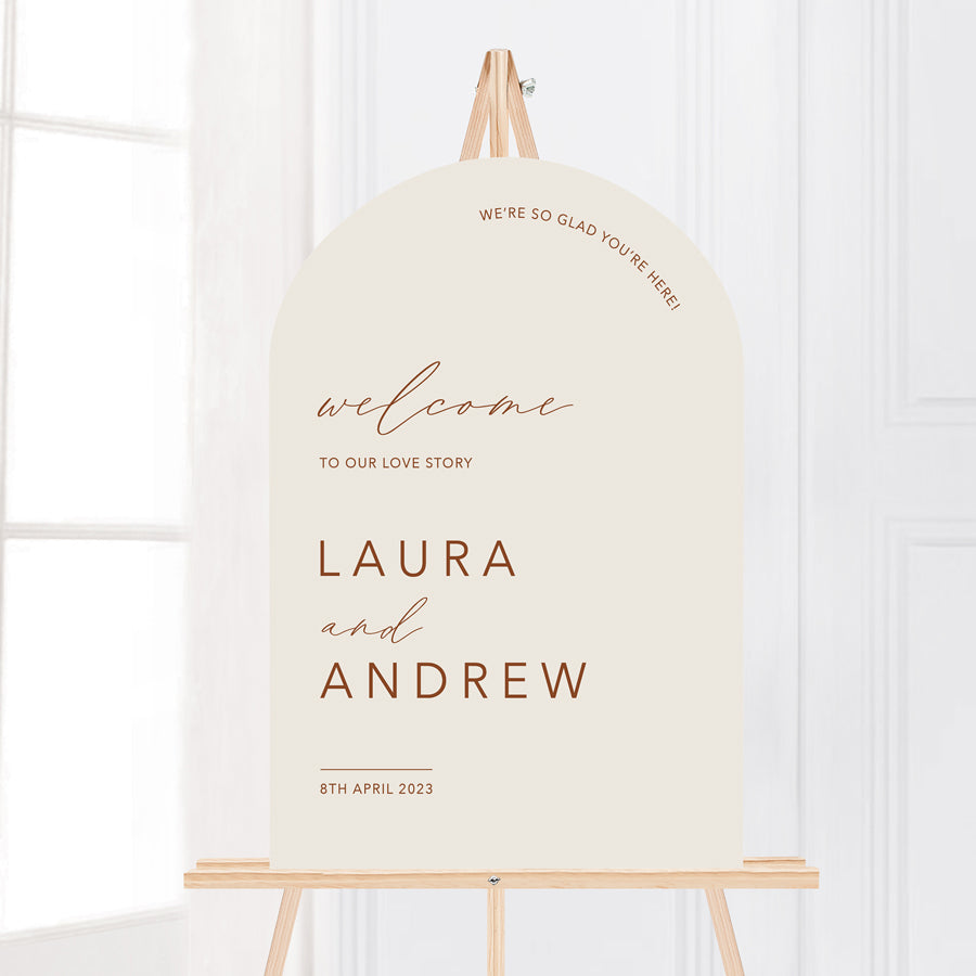 Beautiful arch wedding welcome sign in natural cream beige background with terracotta text. Printed in Australia on smooth board for sitting on an easel.