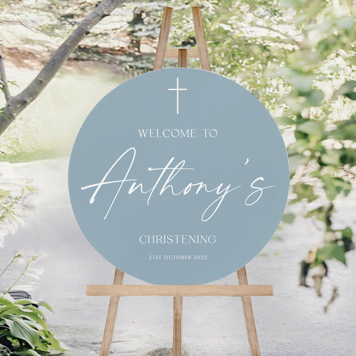 Round Baptism or Christening welcome sign for boys in dusty blue with white text. Christening welcome sign on an easel. Peach Perfect.