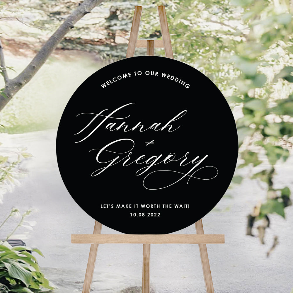 Modern wedding welcome sign on black foamboard with white calligraphy for bride and grooms names. Circle wedding sign board.