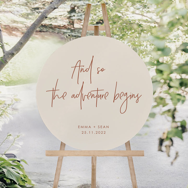And so the adventure begins wedding welcome sign. Circle foamboard sign in neutral beige and terracotta..