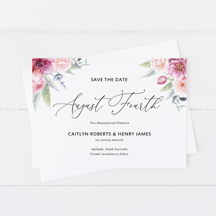 Modern wedding save the date card with pink florals in corners and calligraphy font