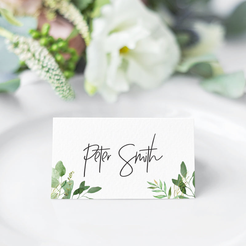 Wedding place cards or name cards with modern script font and green leaves in both corners