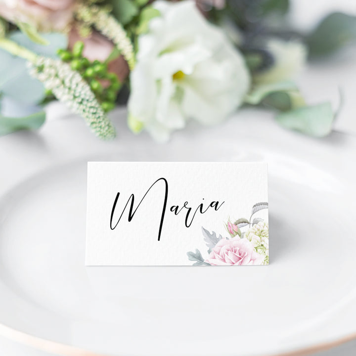Folded wedding place card with calligraphy and pink flowers and greenery in corner