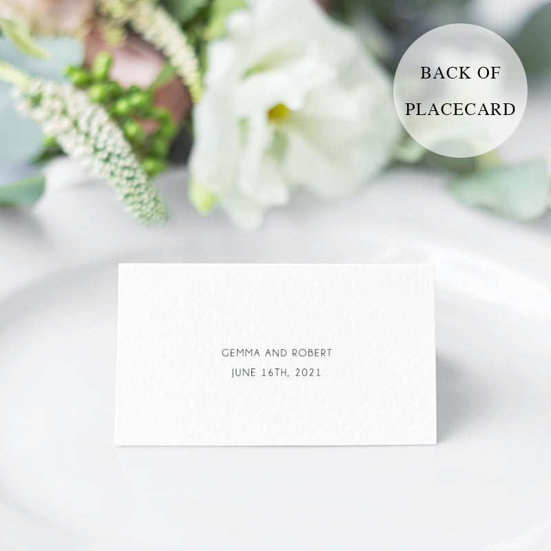 Folded wedding place card with calligraphy and pink flowers and greenery in both corners