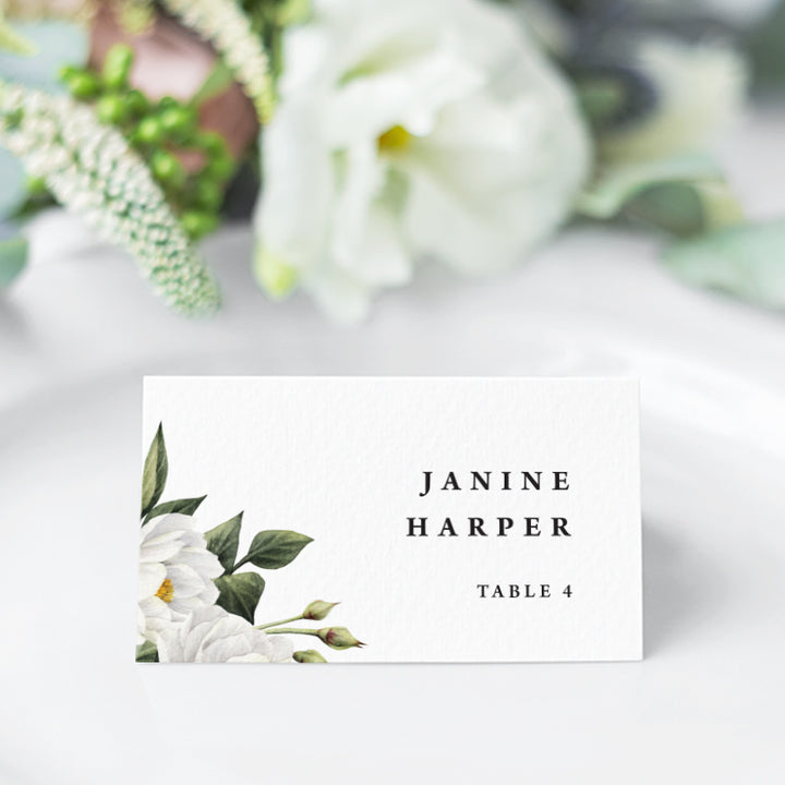Folded wedding name cards or place cards with white flowers and green leaves and modern font style
