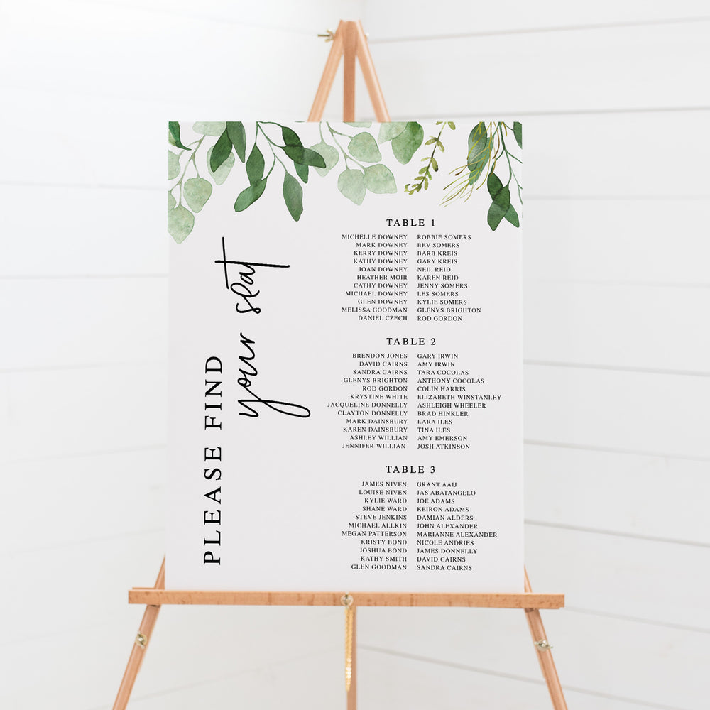 Wedding seating chart on board with greenery leaf border