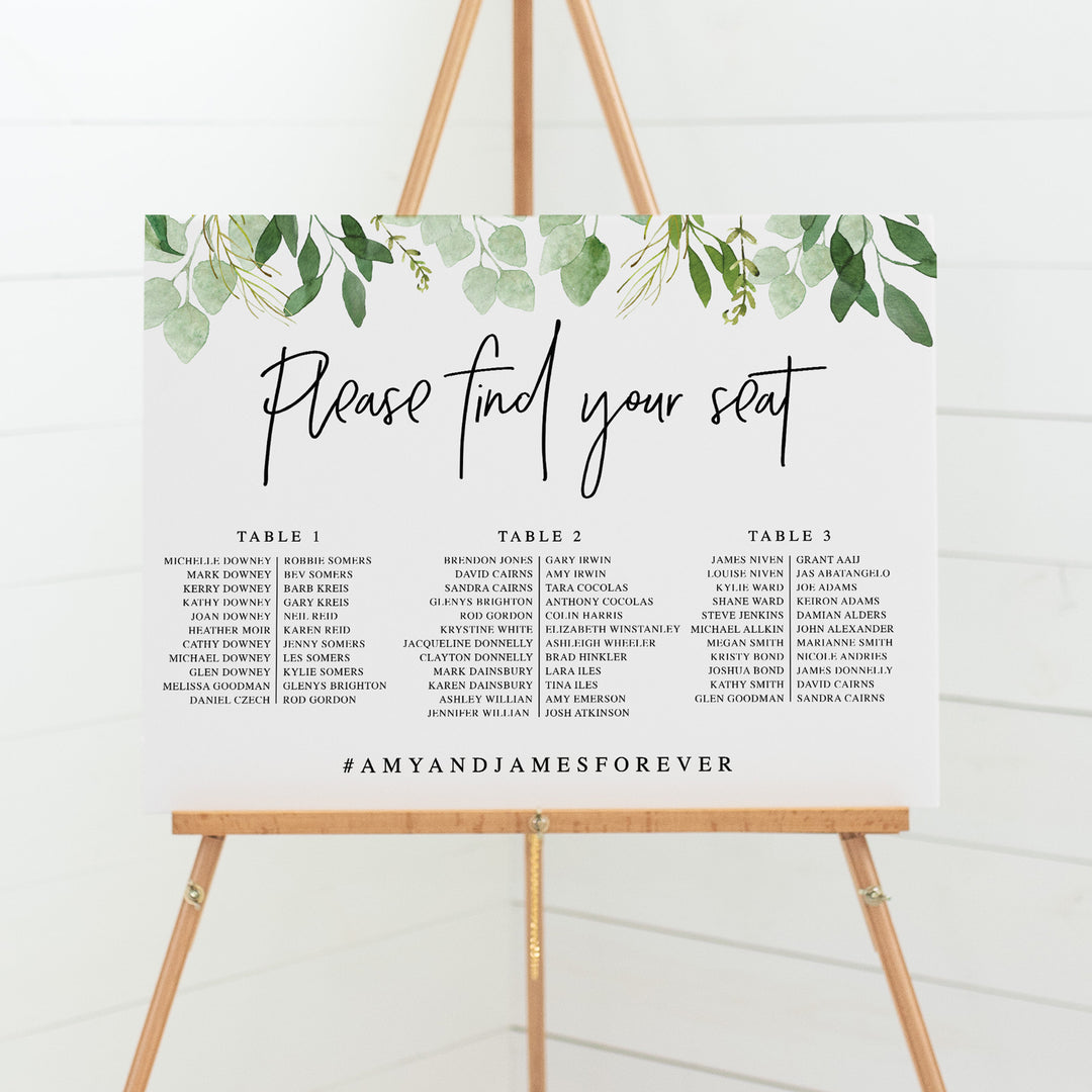 Wedding seating chart on board with greenery leaf border