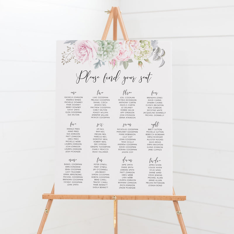 Wedding seating chart or guest name plan with calligraphy heading and soft pink flowers and greenery. Mounted to board for sitting on an easel.