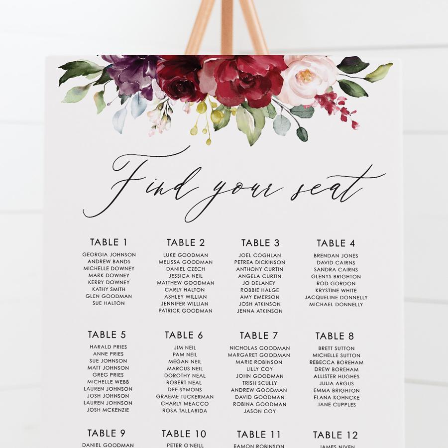 Wedding seating chart with striking red, burgundy and pink florals and foliage