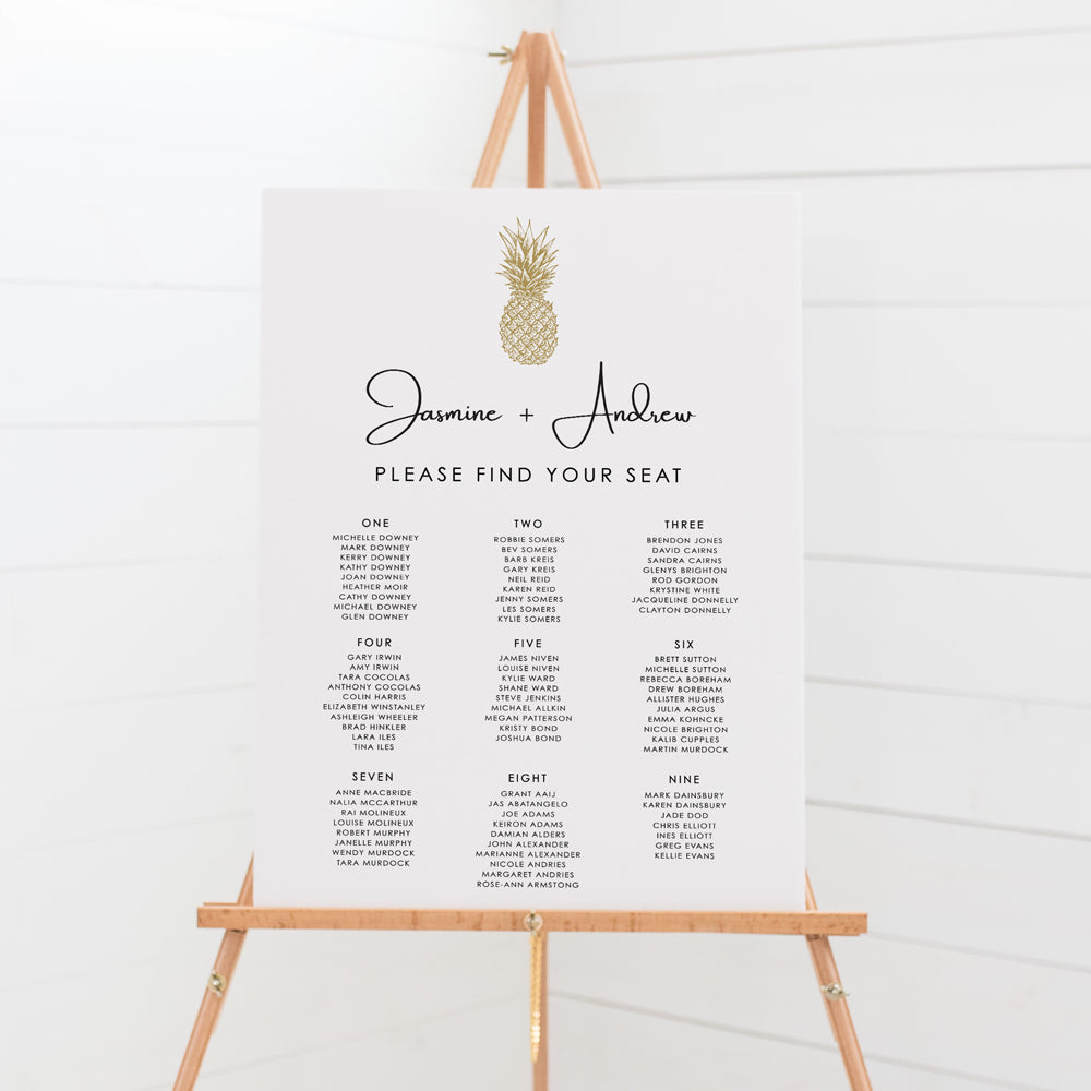 Modern tropical wedding seating chart with a gold tropical hand drawn pineapple and modern calligraphy font for bride and grooms names