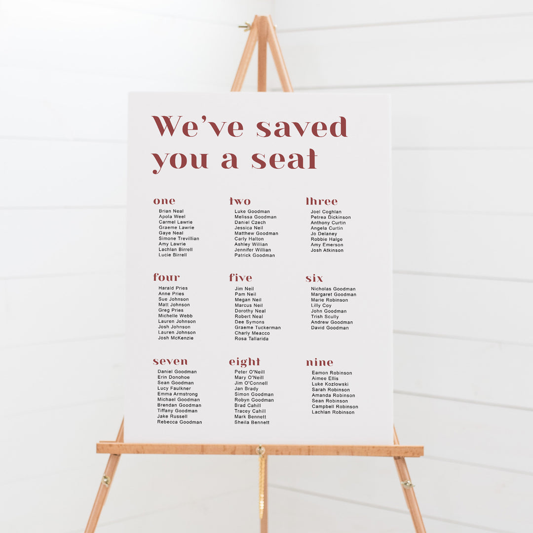 Modern wedding seating chart, we've saved you a seat heading. Terracotta and white text. Mounted to foam board or print your own budget design.
