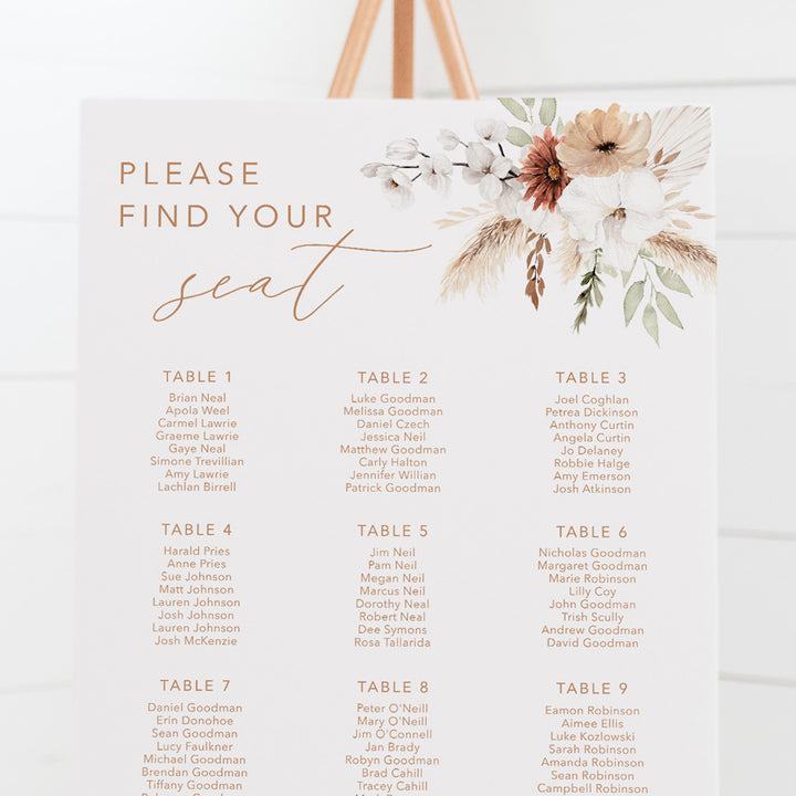 Bohemian wedding seating chart with calligraphy font and watercolour boho flowers, pampas grass and foliage, printed on foamboard for sitting on an easel.