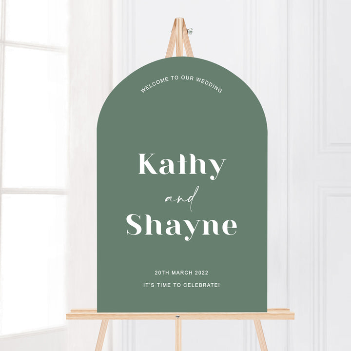 Modern wedding welcome sign in arch shape on easel. Trendy fonts. Forest green and white.
