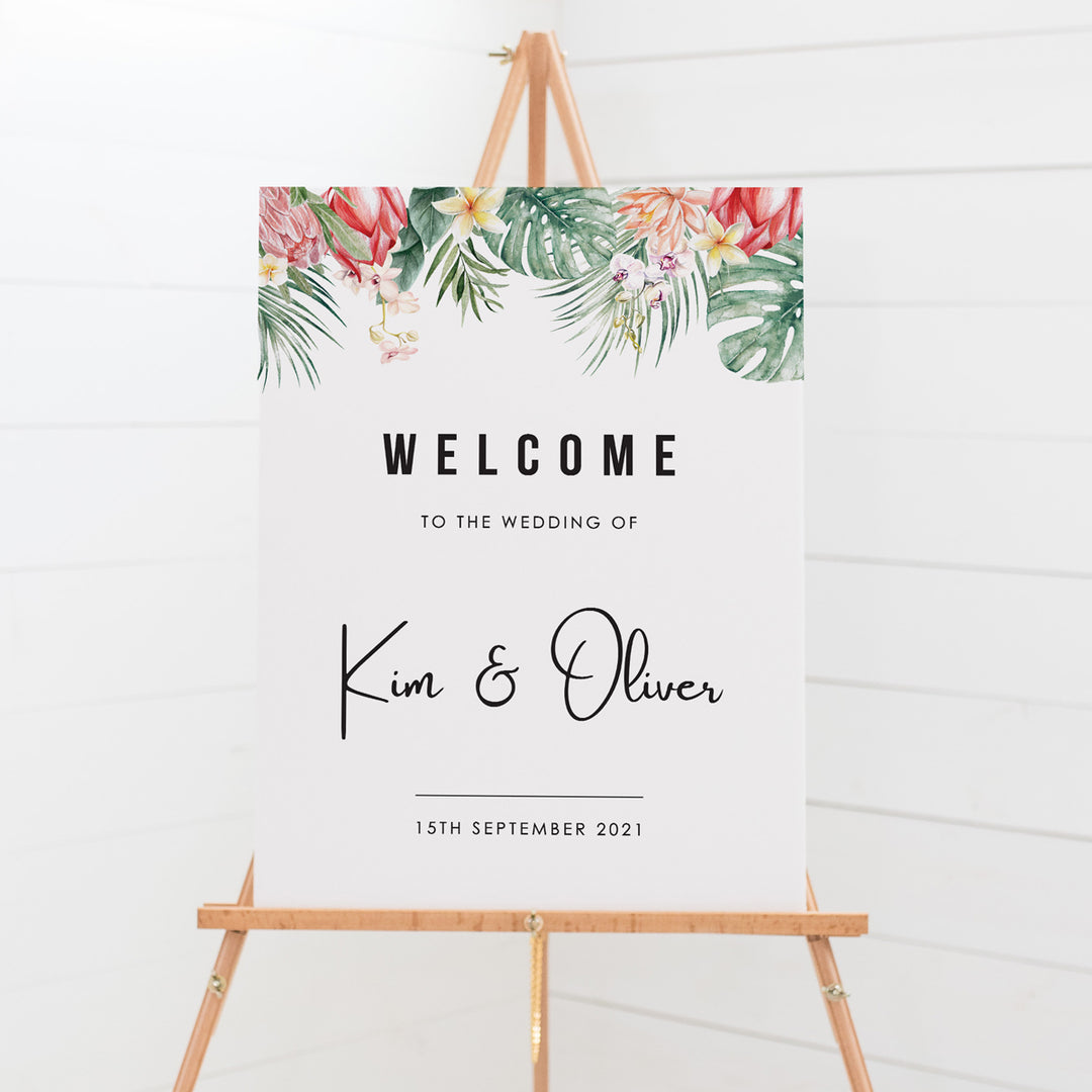 Wedding welcome sign board, tropical leaves and flowers as top border