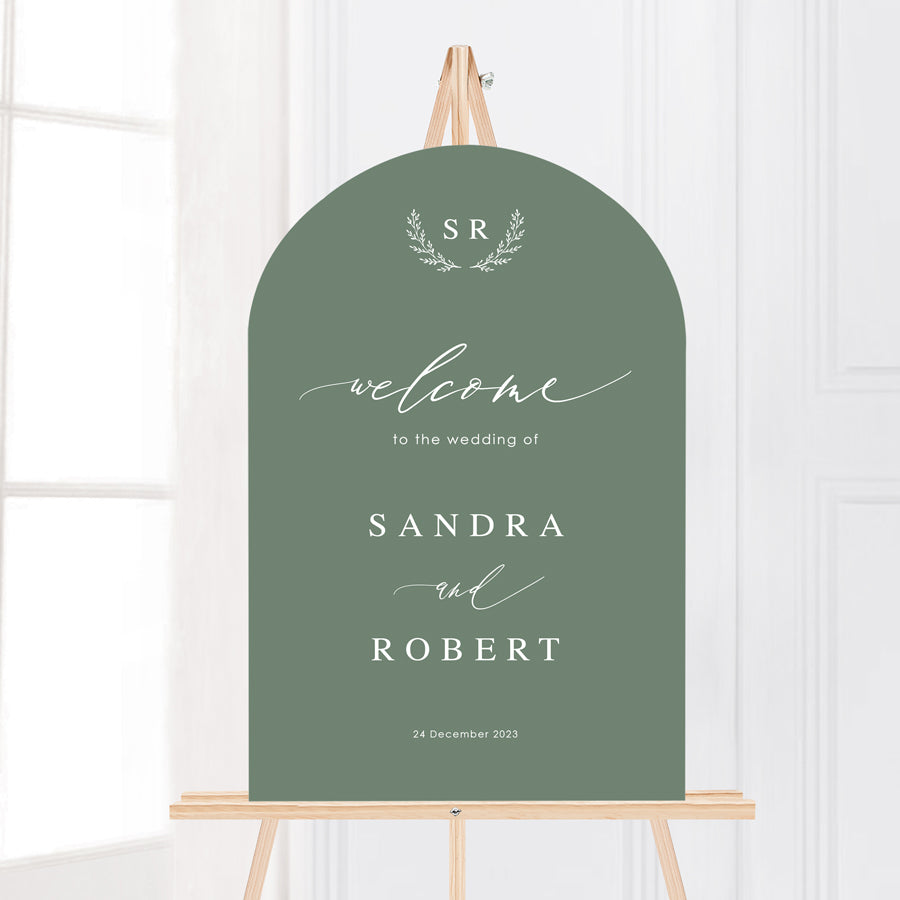 Arch wedding welcome sign board with calligraphy font and monogram of bride and grooms initials in seedling green and white ink. Peach Perfect stationery Australia.